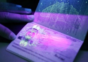 Some of the security features are shown in the United Kingdom's new-style, biometric European Union passports, embedded with a microchip, as it is exposed to ultra-violet rays, at the British Consulate, Monday, Oct. 24, 2005 in Washington.  The occasion was the first U.S. pilot of the U.K.'s biometric passport programme.  (AP Photo/Manuel Balce Ceneta)
